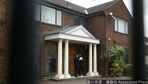 Seen through a metal fence, uniformed British police stand guard outside the house of leading Pakistani politician Altaf Hussain, in north London, Tuesday, June 3, 2014, where they are believed to have arrested Hussain on suspicion of money-laundering. Police in Britain do not name suspects until they are charged, but when asked about Hussain, the Metropolitan Police said a 60-year-old man had been detained at a residence in northwest London on Tuesday, and detectives were searching the property. Hussain, who is 60, heads the Muttahida Qaumi Movement, or MQM, one of Pakistan's major political parties. (AP Photo/Alastair Grant)