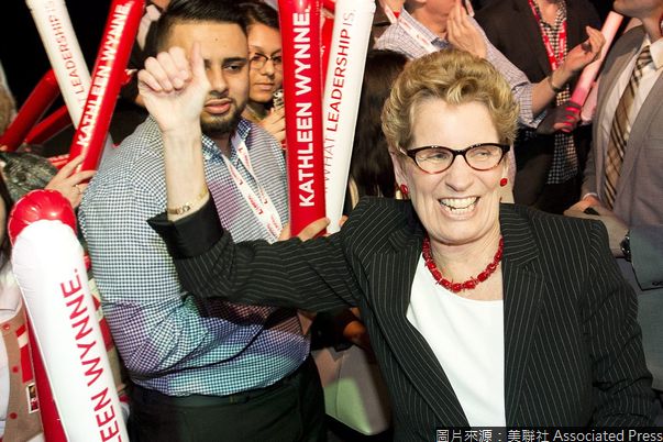 Ontario Premier Kathleen Wynne, left, and her partner Jane Rounthwaite, right, greet supporters and her caucus at a rally during the party's annual general meeting in Toronto on Saturday, March 22, 2014. (AP Photo/The Canadian Press, Nathan Denette)